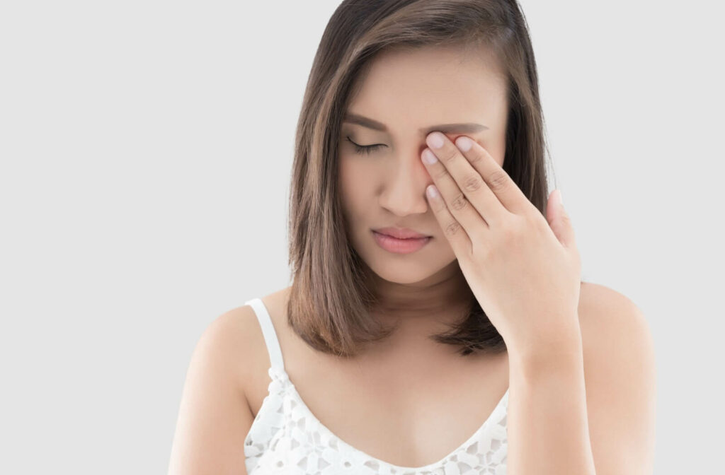 A young woman rubbing her eyes in frustration because of dry eye disease.